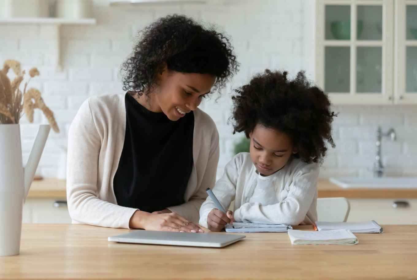 mother is helping her daughter with home schooling